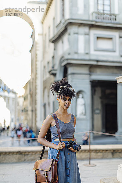 Porträt einer jungen Frau mit Kamera  die die Stadt erkundet  Florenz  Italien