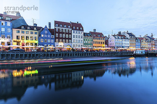 Dänemark  Kopenhagen  Lichtspuren vor einer Reihe von bunten Wohngebäuden entlang des Hafens von Nyhavn