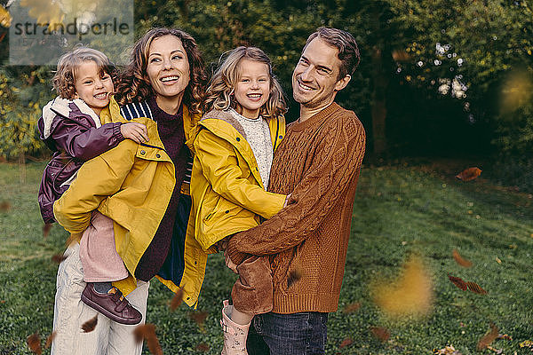 Porträt einer glücklichen Familie mit zwei Töchtern im Herbst im Freien