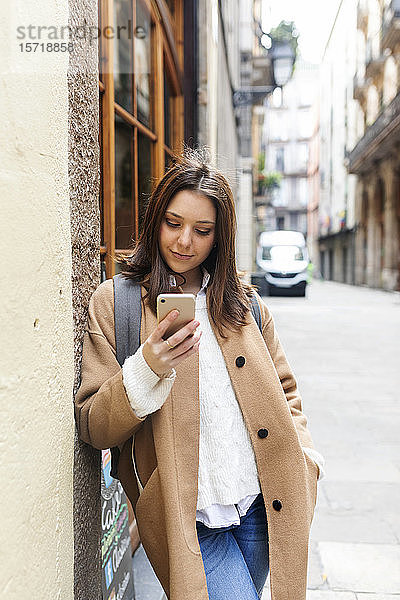 Junge Frau überprüft ihr Telefon in der Stadt  Barcelona  Spanien