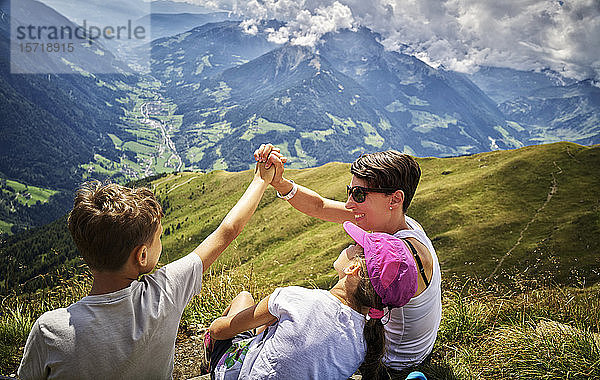 Glückliche Mutter mit zwei Kindern bei einer Wanderpause in alpiner Landschaft  Passeiertal  Südtirol  Italien