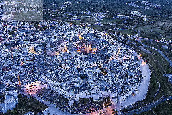 Italien  Provinz Brindisi  Ostuni  Luftaufnahme der Altstadtzitadelle umgeben von weißen Häusern in der Abenddämmerung