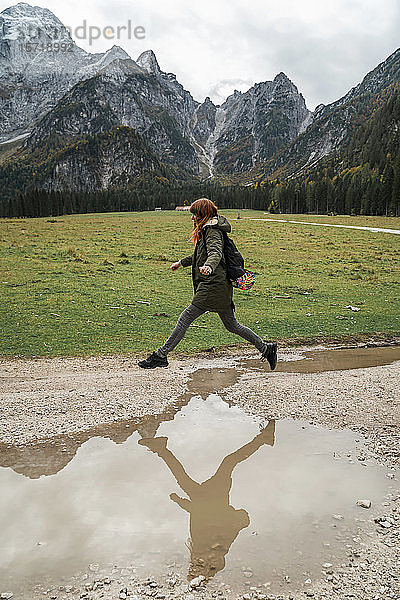 Wanderin springt über Pfütze  Friaul-Julisch Venetien  Italien