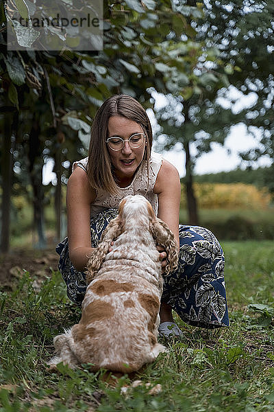 Frau auf einer Wiese mit ihrem Hund