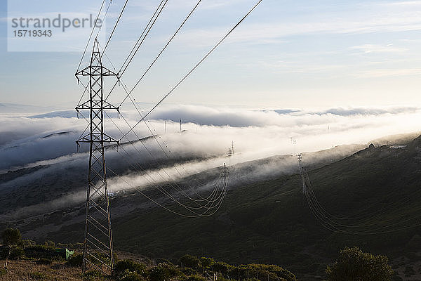 Spanien  Strommast gegen wolkenumhüllte Hügel von Gibraltar