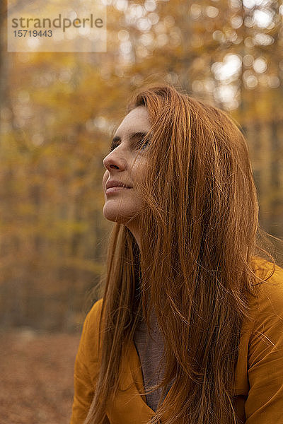 Porträt einer rothaarigen jungen Frau im Herbstwald