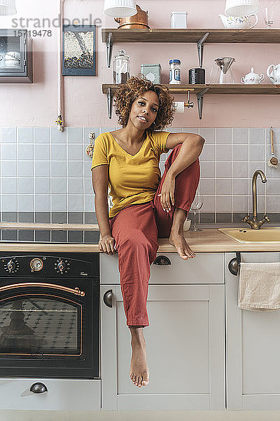 Porträt einer entspannten jungen Frau in der Küche