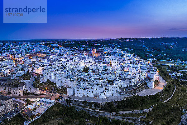 Italien  Provinz Brindisi  Ostuni  Luftaufnahme der Altstadtzitadelle umgeben von weißen Häusern in der Abenddämmerung