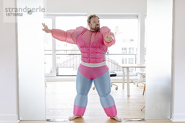 Türsteher im Büro in rosa Bodybuilder-Kostüm
