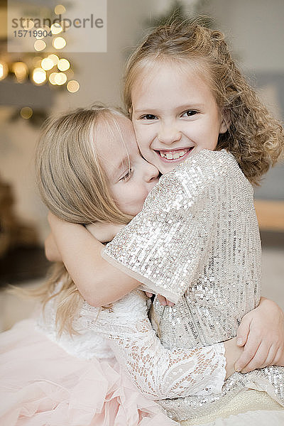 Porträt von zwei fröhlichen kleinen Mädchen  die sich umarmen