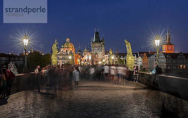 Karl?v most  Menschen auf der Karlsbrücke in der Abenddämmerung  in der Hinterkuppel der Kreuzherrenkirche mit Altstädter Brückenturm  Prag  Böhmen  Tschechische Republik  Europa