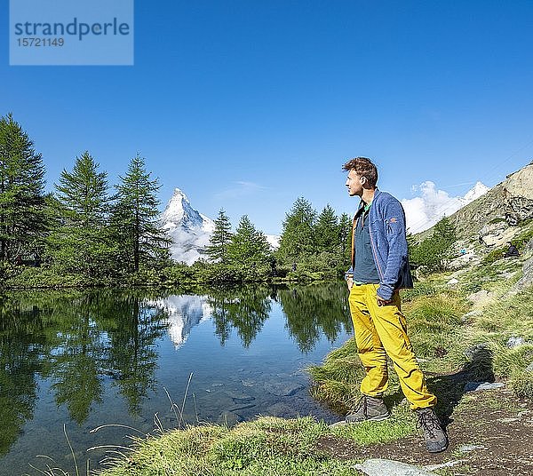 Wanderer am Grindijsee  schneebedecktes Matterhorn spiegelt sich im See  5-Seen-Wanderweg  Wallis  Schweiz  Europa