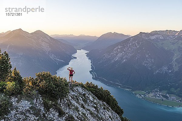Sonnenuntergang  junge Frau blickt über Berglandschaft  Blick vom Bärenkopf zum Achensee  links Seebergspitze und Seekarspitze  rechts Rofangebirge  Tirol  Österreich  Europa