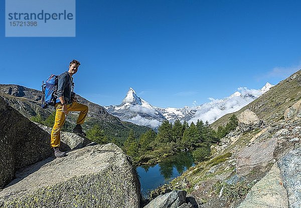 Wanderer auf Felsen stehend  hinter dem Grindij-See und dem schneebedeckten Matterhorn  Wallis  Schweiz  Europa