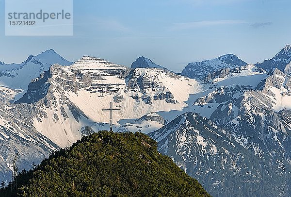 Gipfelkreuz am Martinskopf  Blick vom Herzogstand  Karwendelgebirge im Hintergrund  schneebedeckte Berge  Bayern  Deutschland  Europa