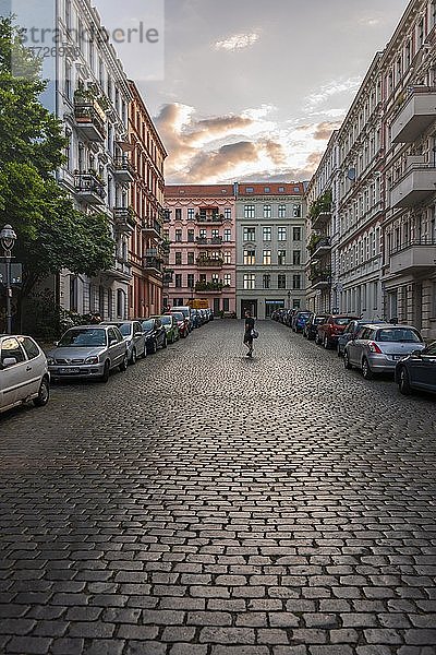 Mann geht über eine Kopfsteinpflasterstraße in einem Wohngebiet  Berlin  Deutschland  Europa