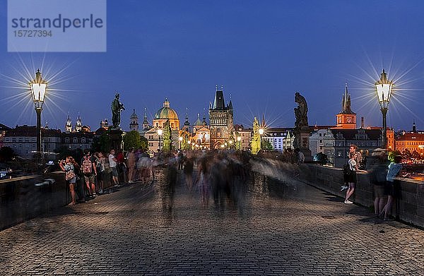 Karl?v most  Menschen auf der Karlsbrücke in der Abenddämmerung  in der Hinterkuppel der Kreuzherrenkirche mit Altstädter Brückenturm  Prag  Böhmen  Tschechische Republik  Europa