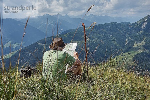 Wanderer rastet auf Almwiese mit Blick auf das Lesachtal und die Karnischen Alpen  Almgebiet Mussen  Kärnten  Alpen  Österreich  Europa