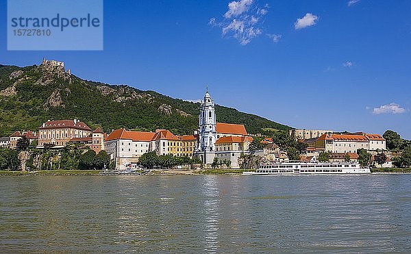 Ausflugsschiff auf der Donau vor der Barockkirche des Stiftes Dürnstein  im Hintergrund die Burgruine Dürnstein  Wachau  Niederösterreich  Österreich  Europa