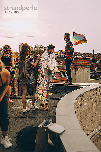 Freunde arrangieren Decke auf der Terrasse für eine Dachparty in der Stadt