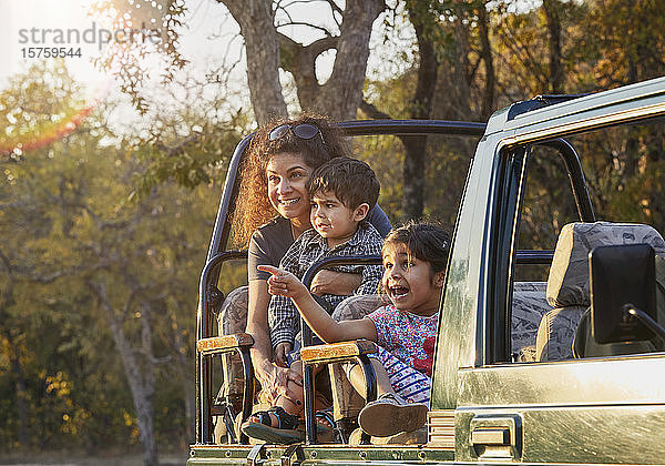 Mutter und Kinder genießen die Natur vom Geländewagen aus