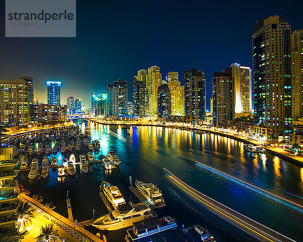 Nachtszene mit Stadtsilhouette und im Hafen vertäuten Booten  Dubai