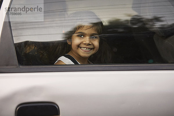 Kleines Mädchen schaut durch ein Autofenster hinaus