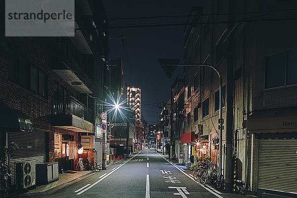 Nachtszene einer leeren Straße und alter Einzelhandels- und Wohnblockhäuser  Osaka  Japan