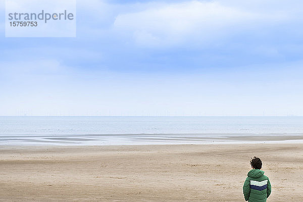 Junge genießt Aussicht am Strand