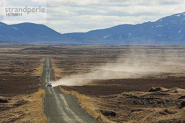 Fahrzeug hinterlässt Staubspur auf Schotterstraße  Dettifoss  Island