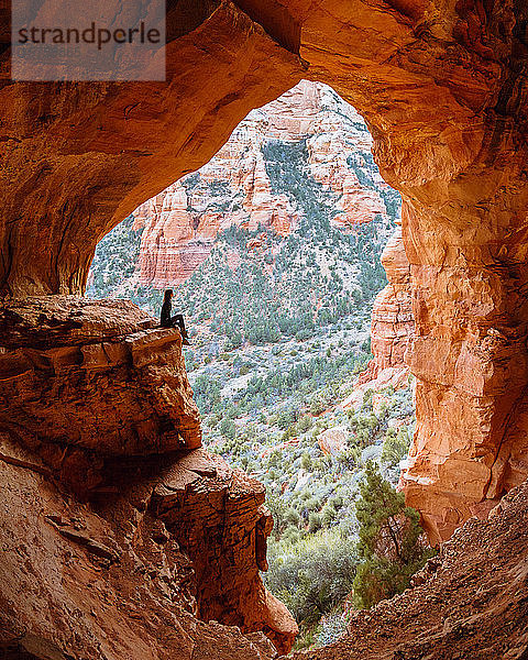 Frau sitzt auf einer Felskante in einer Höhle  Sedona  Arizona  Vereinigte Staaten