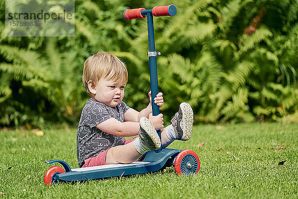 Kleinkind spielt mit Roller im Park