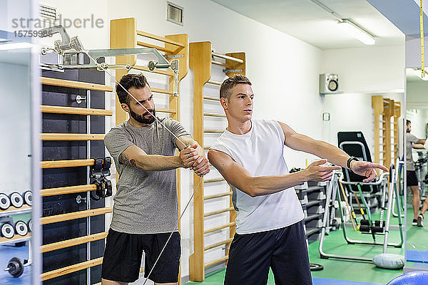 Mann trainiert Freund im Fitnessstudio