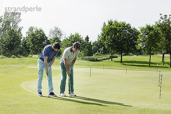 Freunde spielen Golf auf dem Golfplatz