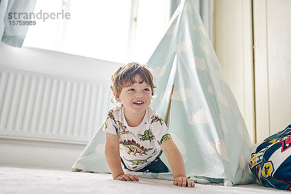 Kleinkind spielt zu Hause in seinem Schlafzimmer in einem Tipi