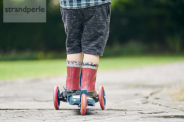 Kleinkind fährt auf einem Roller im Park