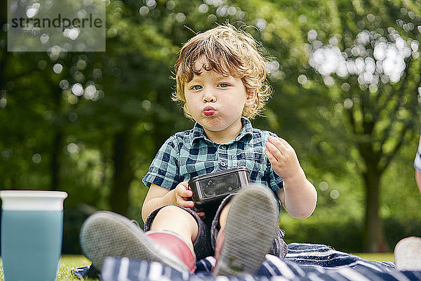 Kleinkind beim Essen im Park