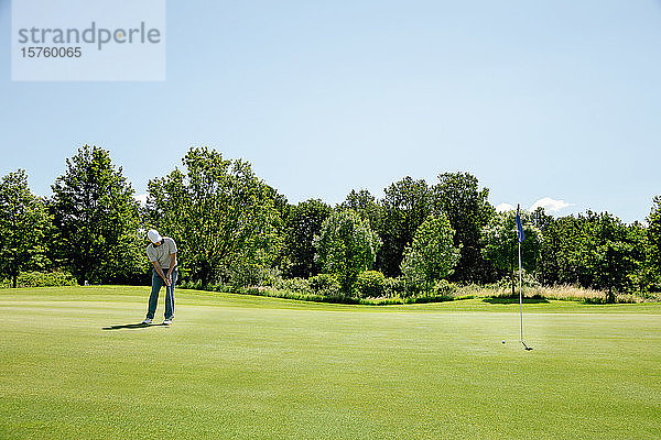 Mann spielt Golf auf dem Golfplatz