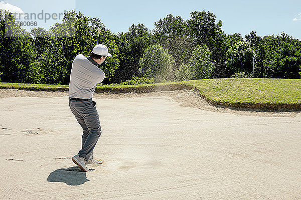 Mann spielt Golf auf dem Golfplatz