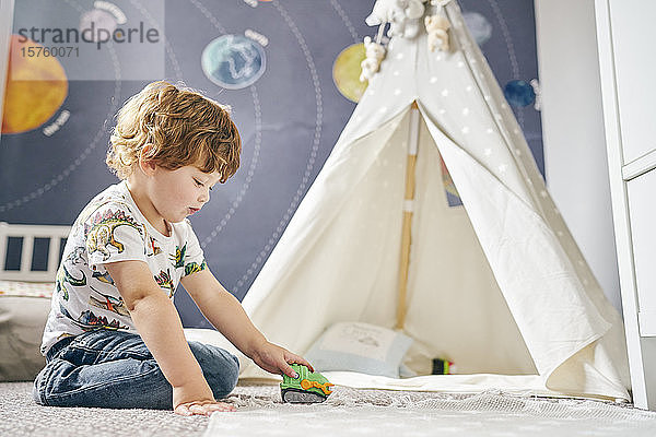 Kleinkind spielt im Zimmer  Kinder-Tipi  Wandgemälde des Sonnensystems an der Wand