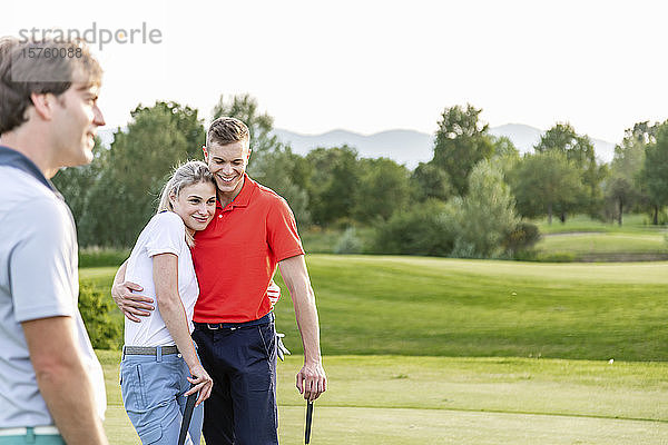 Mann und Paar umarmen sich auf dem Golfplatz