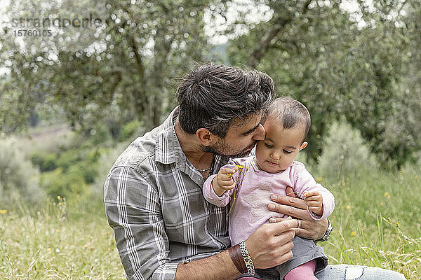 Vater küsst kleines Mädchen im Garten  Florenz  Italien