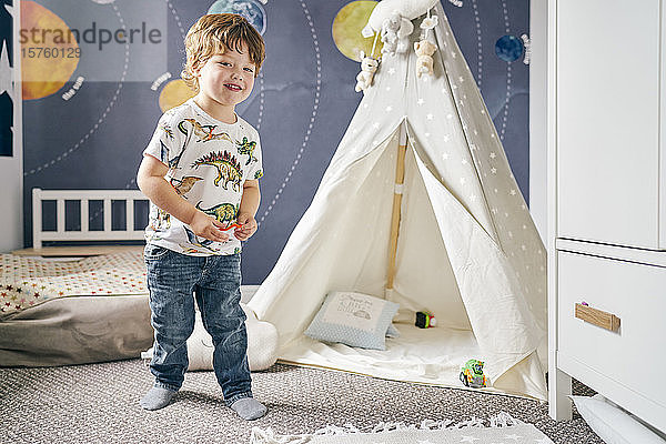 Kleinkind spielt im Zimmer  Kinder-Tipi  Wandgemälde des Sonnensystems an der Wand