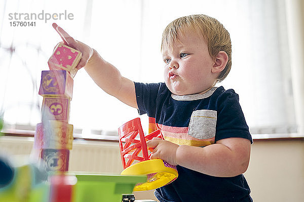 Kleinkind spielt mit Bausteinen im Zimmer