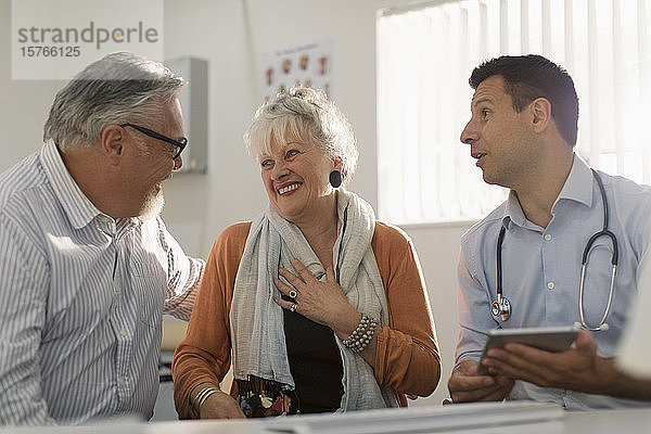 Arztgespräch mit einem glücklichen älteren Paar in einer Arztpraxis