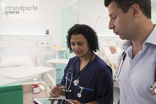 Ärzte mit digitalem Tablet bei der Visite  Beratung im Krankenhauszimmer