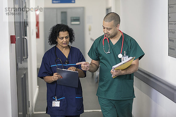 Arzt und Chirurg besprechen Krankenakte  machen Visite im Krankenhauskorridor
