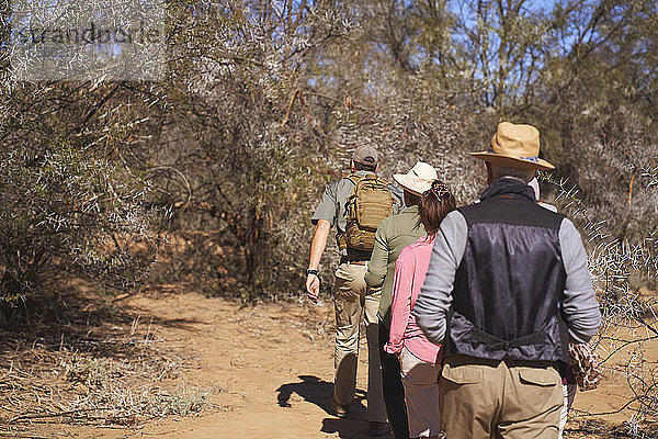 Safari-Reiseleiter führt Gruppe im sonnigen Grasland Südafrikas