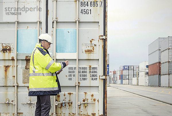 Hafenarbeiter bei der Kontrolle von Frachtcontainern in einer Werft