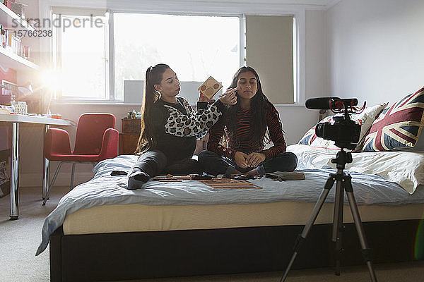 Teenager-Mädchen beim Vloggen  die auf dem Bett Make-up auftragen